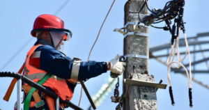 An electrician works on power lines.