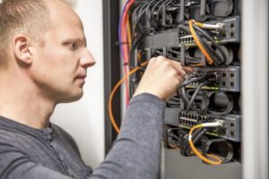 An electrician is placing wires in the correct places.